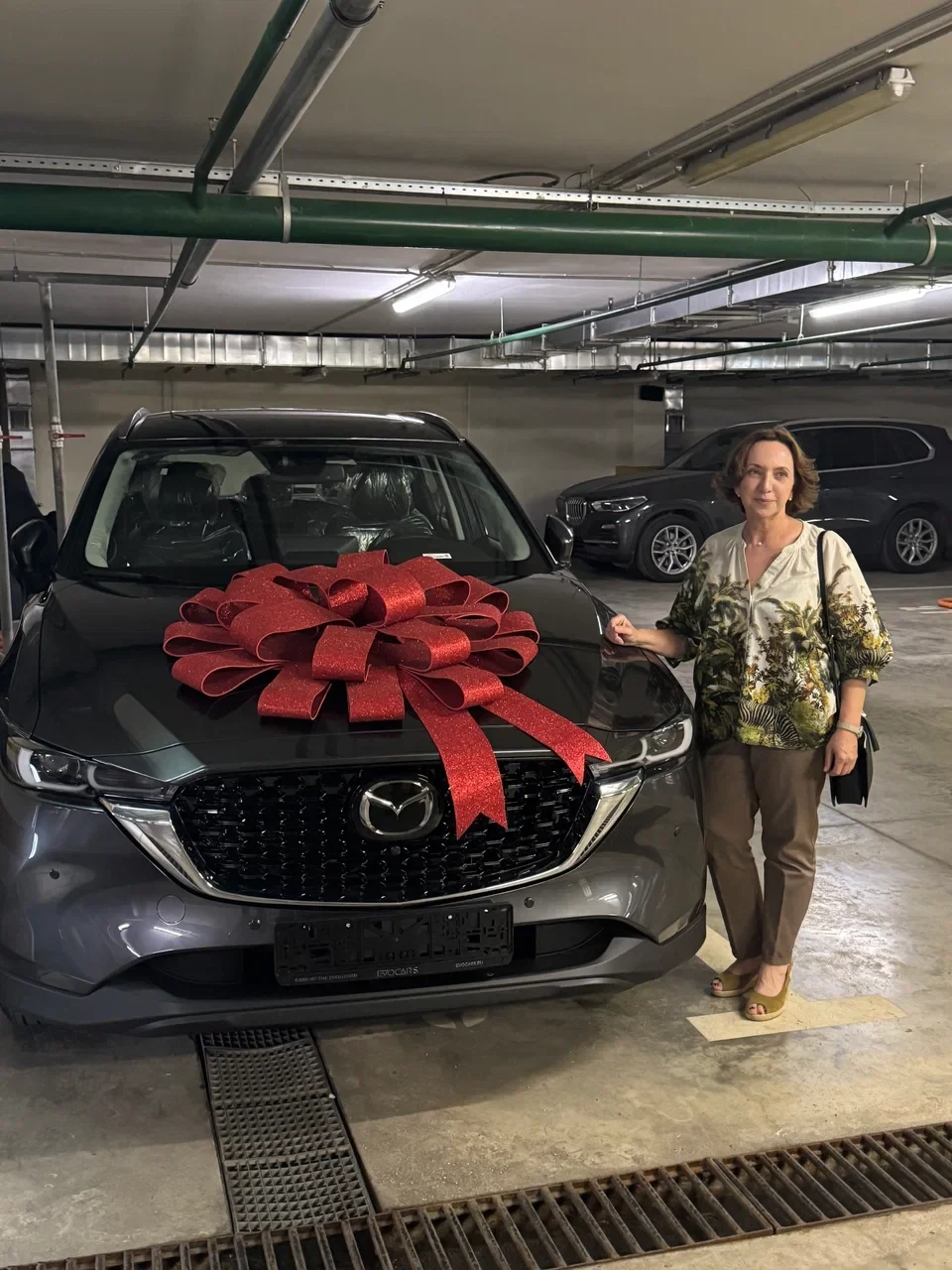 Клиентка EVOCARS с автомобилем Mazda в день выдачи